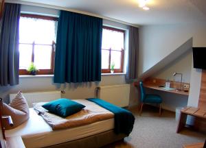 a bedroom with a bed and a desk and windows at Schlossgartenpassage in Ohrdruf