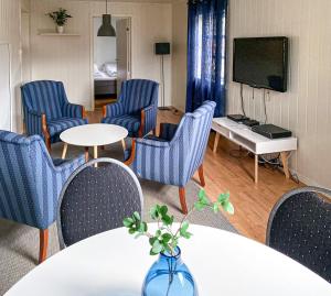 een kamer met stoelen, een tafel en een tv bij Mosjøen Romutleie - Sentrum in Mosjøen