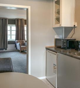 a small kitchen with a table and a microwave at Mosjøen Romutleie - Sentrum in Mosjøen