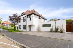 een wit huis met een basketbalring bij Studio het Strandhuis KA05 in Vlissingen
