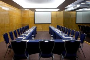 a conference room with blue tables and chairs and a whiteboard at Sol Ipanema Hotel in Rio de Janeiro