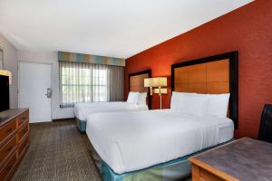 a hotel room with two beds and a flat screen tv at La Quinta Inn Tampa Airport Stadium Westshore in Tampa