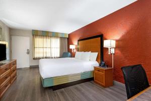 a hotel room with a bed and a television at La Quinta Inn Tampa Airport Stadium Westshore in Tampa