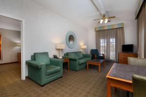 a living room with two green chairs and a table at La Quinta Inn Tampa Airport Stadium Westshore in Tampa