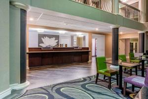 a lobby with a waiting area with green chairs at La Quinta by Wyndham Raleigh Durham Intl AP in Morrisville