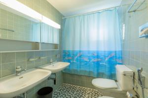 y baño con lavabo, aseo y cortina de ducha. en Hostel Casa Franco en St. Moritz
