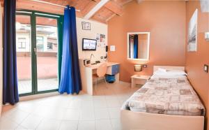 Schlafzimmer mit einem Bett, einem Schreibtisch und einem Fenster in der Unterkunft Central Hostel BG in Bergamo