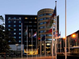 
a tall building with a flag on top of it at Pullman Brussels Centre Midi in Brussels
