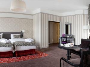 a bedroom with a bed and a living room with a table at Mercure Arbat Moscow in Moscow