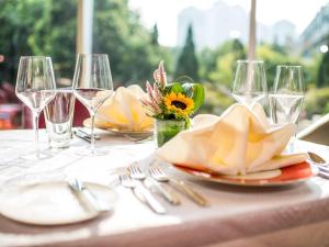 a table with plates and wine glasses on it at Pullman Linyi Lushang in Linyi
