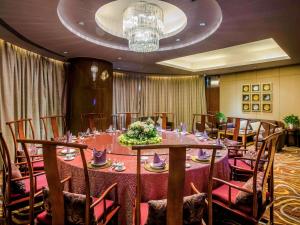 a conference room with a long table and chairs at Pullman Linyi Lushang in Linyi