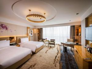 a hotel room with two beds and a desk at Pullman Linyi Lushang in Linyi