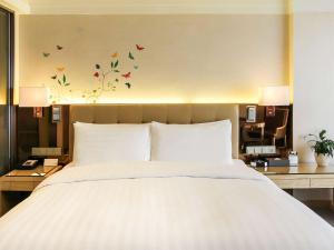a bedroom with a large bed with butterflies on the wall at Pullman Linyi Lushang in Linyi