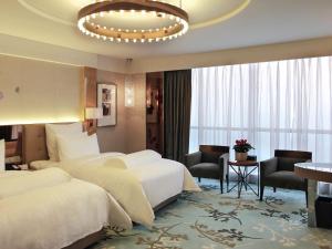 a hotel room with two beds and a chandelier at Pullman Linyi Lushang in Linyi