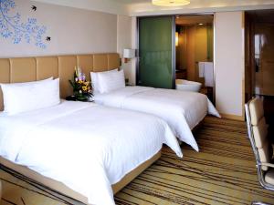 a hotel room with two beds and a bathroom at Pullman Linyi Lushang in Linyi