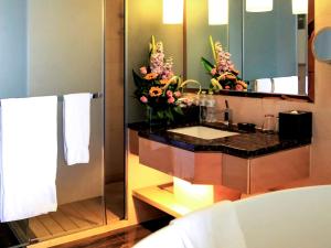a bathroom with a sink and a mirror at Pullman Linyi Lushang in Linyi