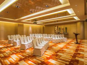 a conference room with white chairs and a podium at Pullman Linyi Lushang in Linyi