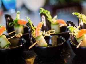 a row of black bowls filled with sushi at Pullman Linyi Lushang in Linyi