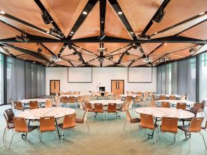 a large room with tables and chairs in it at Novotel Auckland Airport in Auckland