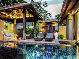 a hotel room with a pool and a balcony at Pullman Phuket Arcadia Naithon Beach - SHA Extra Plus in Nai Thon Beach