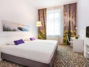 une chambre d'hôtel avec deux lits et une télévision dans l'établissement Ibis Styles Frankfurt City, à Francfort-sur-le-Main 70 autres photos