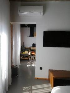 a living room with a flat screen tv and a kitchen at 13 suites in León
