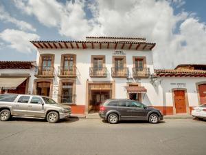 two cars parked in front of a building at Hotel Patzcuaro in Pátzcuaro