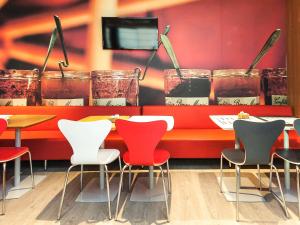 a restaurant with a red table and chairs at ibis Mogi das Cruzes Shopping in Mogi das Cruzes