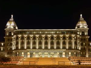Un grand bâtiment est éclairé la nuit. dans l'établissement Sofitel Montevideo Casino Carrasco & Spa, à Montevideo