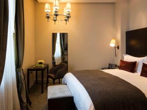 a hotel room with two beds and a lamp at Sofitel Montevideo Casino Carrasco & Spa in Montevideo