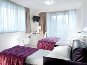 a hotel room with two beds and a tv at Mercure Hotel Rimini Artis in Rimini