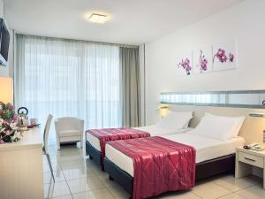 um quarto de hotel com uma cama e uma secretária em Mercure Hotel Rimini Artis em Rimini