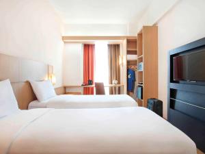 A bed or beds in a room at Ibis Bandung Trans Studio