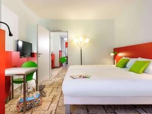 een hotelkamer met een bed en een bureau bij ibis Styles Karlsruhe Ettlingen in Ettlingen
