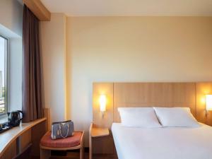 a hotel room with a bed and a lamp at ibis Leiden Centre in Leiden