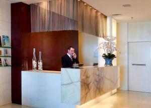 a man standing at a counter in a lobby at Sol Ipanema Hotel in Rio de Janeiro