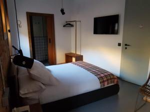 a bedroom with a white bed and a television at 13 suites in León