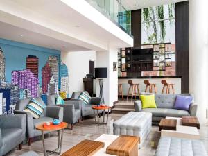 a lobby with couches and tables in a building at All Seasons Jakarta Thamrin in Jakarta