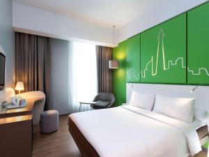 a hotel room with a bed and a green wall at All Seasons Jakarta Thamrin in Jakarta +37 photos