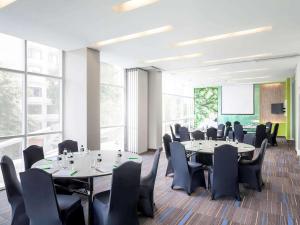 a conference room with tables and chairs and a screen at All Seasons Jakarta Thamrin in Jakarta