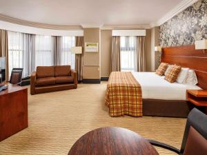 レスターにあるJupiter Hotel Leicester The Grandのベッドとデスクが備わるホテルルームです。