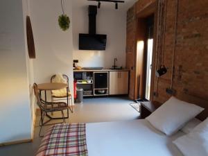 a kitchen with a stove, microwave and a bed at 13 suites in León