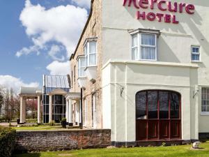 un grand bâtiment blanc avec un panneau d'hôtel dans l'établissement Mercure York Fairfield Manor Hotel, à York