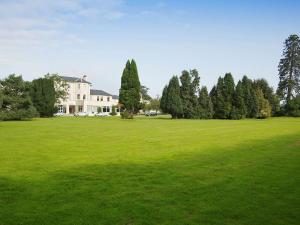 a large green field with a house and trees at Mercure Maidstone Great Danes Hotel in Maidstone