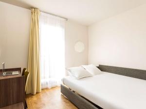 Postel nebo postele na pokoji v ubytování Aparthotel Adagio Access Carrières Sous Poissy