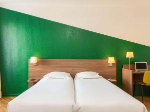 Postel nebo postele na pokoji v ubytování Aparthotel Adagio Access Carrières Sous Poissy