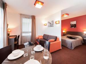 une chambre d'hôtel avec une table à manger et un lit dans l'établissement Aparthotel Adagio Access Poitiers, à Poitiers