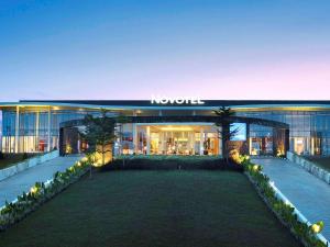 a building with a lawn in front of it at Novotel Banjarmasin Airport in Banjarbaru