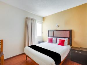 a bedroom with a large bed with red pillows at Hotel Patzcuaro in Pátzcuaro