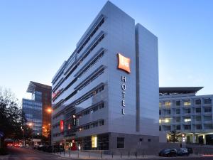 un grand bâtiment avec un panneau d'hôtel dans l'établissement Hotel Ibis Lisboa Parque das Nações, à Lisbonne